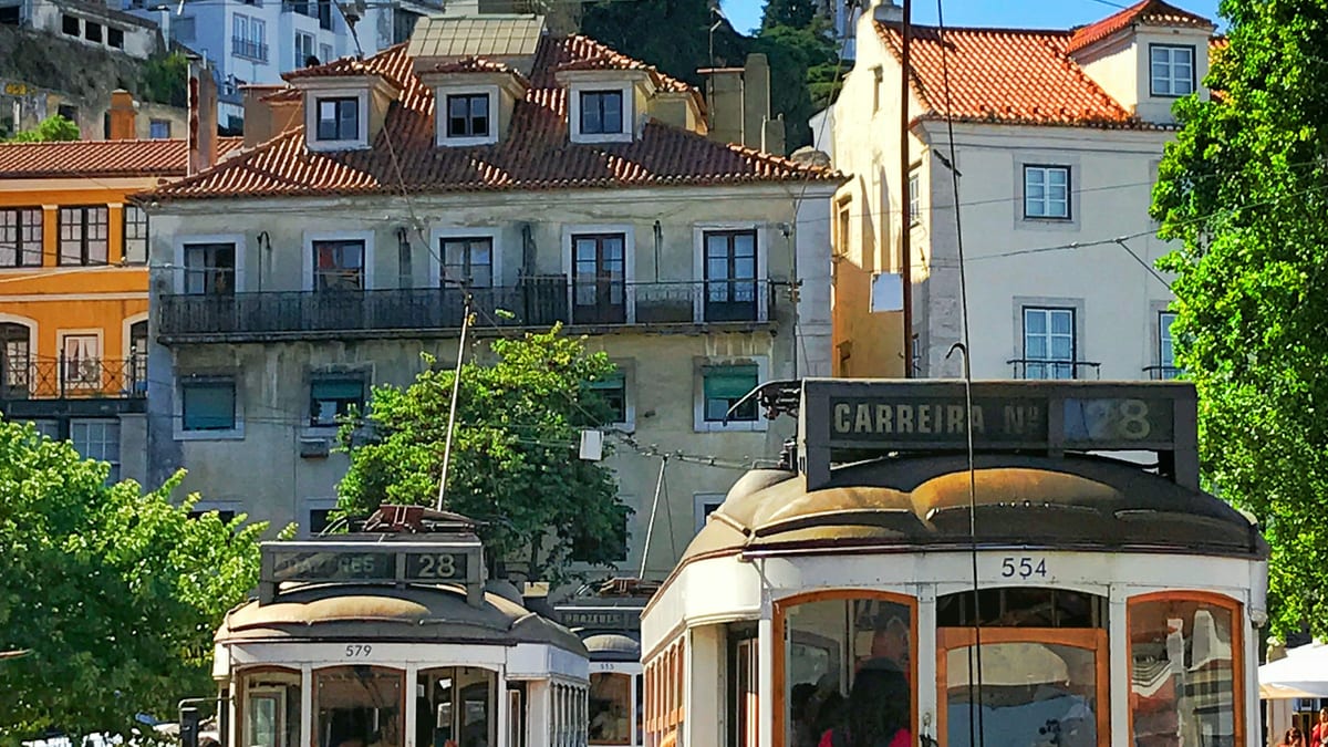 Lisbon yellow trams and hillside blocks — tax