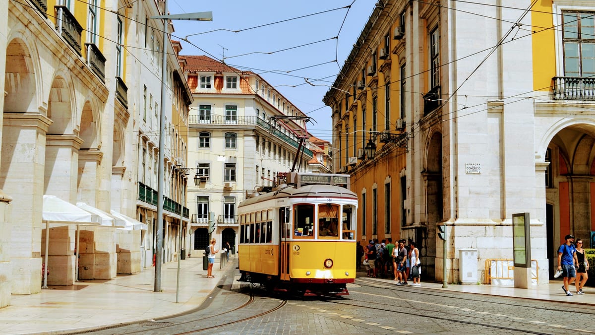 Lisbon yellow tram on arcade street — stay